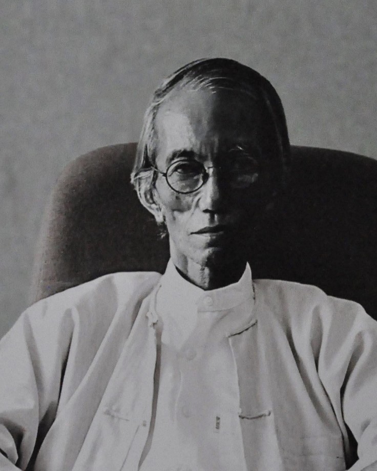 Black-and-white portrait of Aung Myint seated in a chair